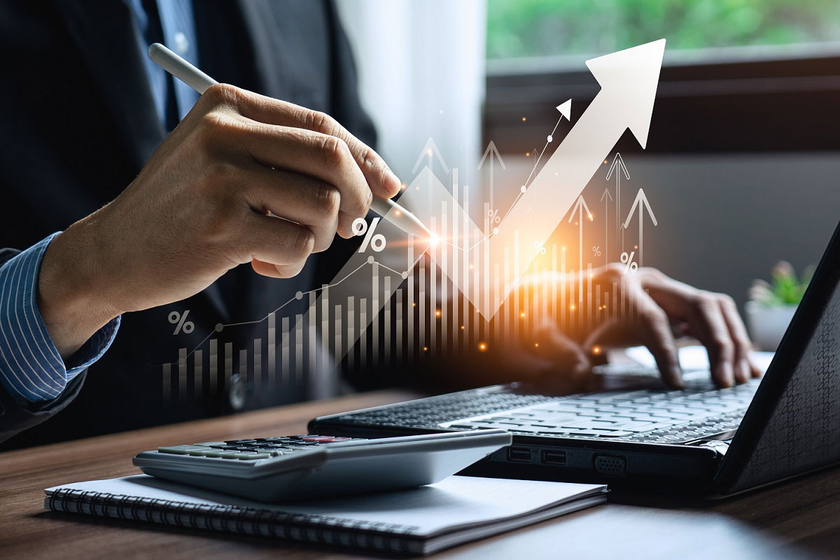 Accountant working on a laptop with a graphic overlay representing economic growth